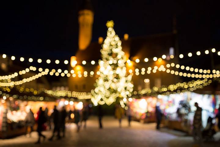 Foto på en lysande, stor, julgran på ett torg